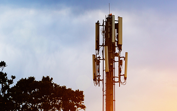 Oberer Abschnitt eines Mobilfunkturms vor blauem Himmel
