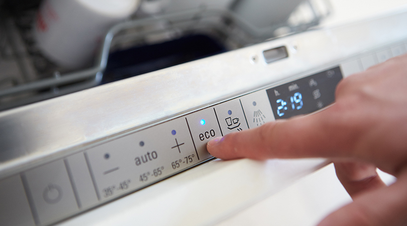 Close up of hand of person operating washing machine