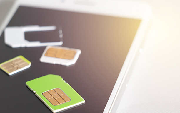 Verschiedene SIM-Karten liegen auf dem Bildschirm eines Smartphones