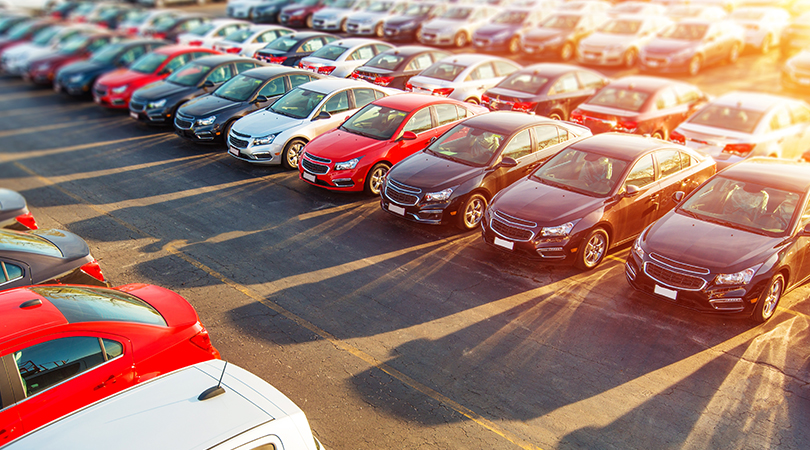 Different colored cars lined up in a parking lot