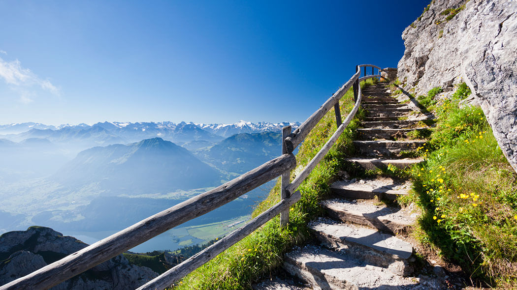A stone staircase on a mountain leads up toward the summit.