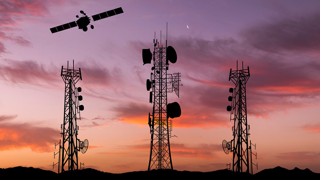 Satellit und Mobilfunkmasten vor Abendhimmel