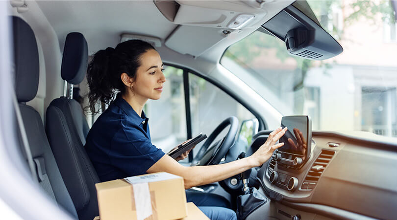 Parcel delivery driver navigating in delivery vehicle