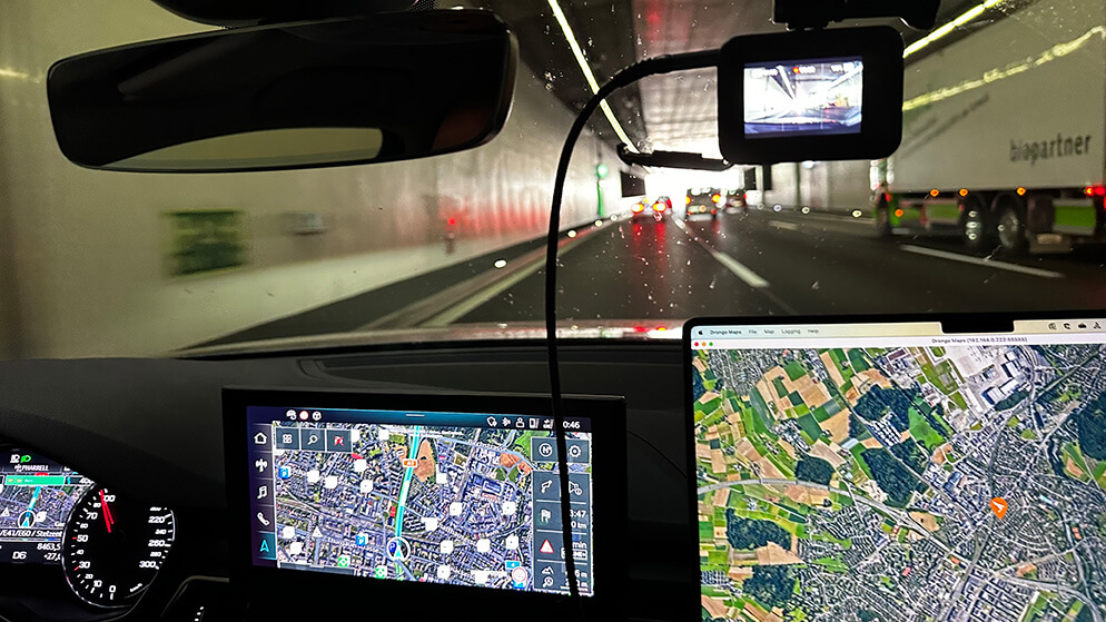 Fahrt durch den Gotthard-Straßentunnel, Displays von Navi und Laptop mit Route