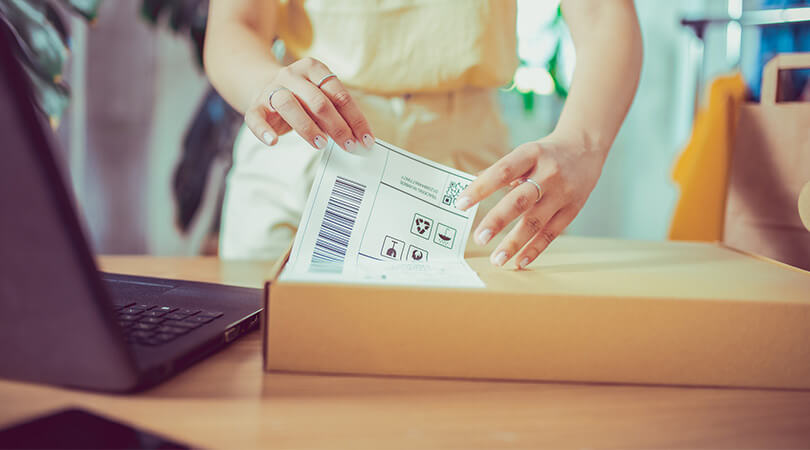 Woman prepares package with return label for further shipment