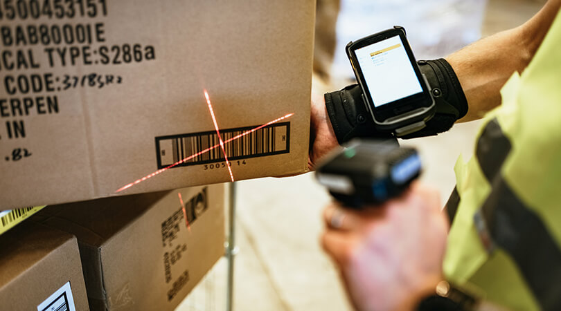 Person scans package with identification code to retrieve shipment information