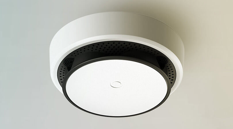 A mobile phone smoke detector attached to the ceiling.