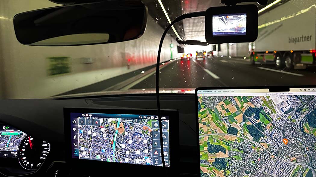 Auto-Cockpit mit Navi, Heckkamera und Laptop bei Tunneldurchfahrt