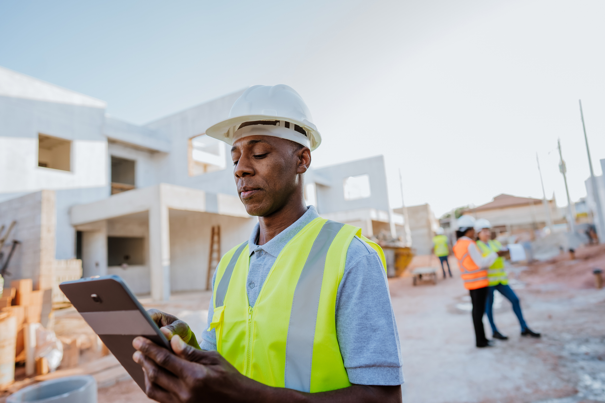 Mann mit Tablett auf einer digitalen Baustelle