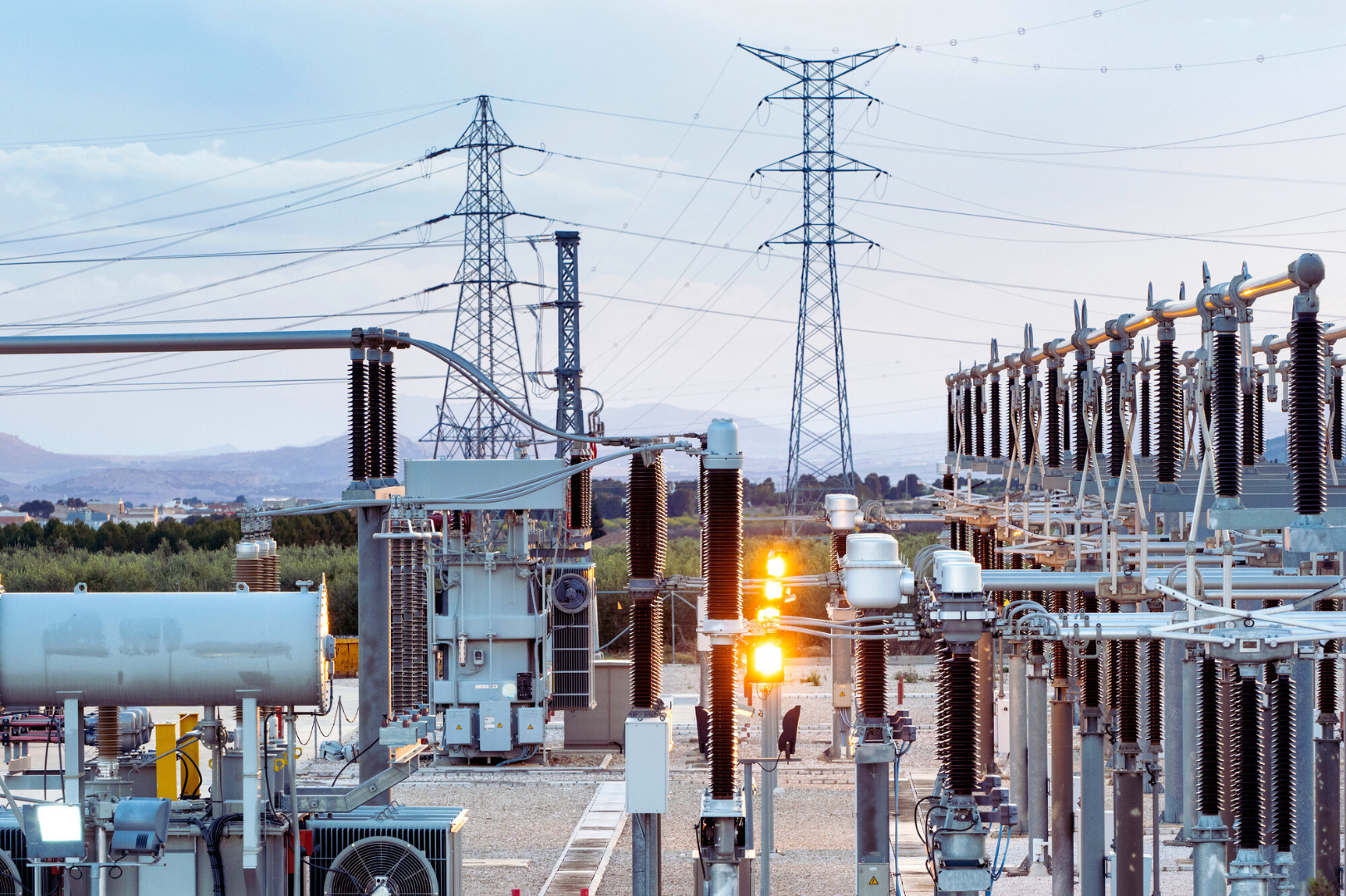 Power plant with electricity pylons in the background