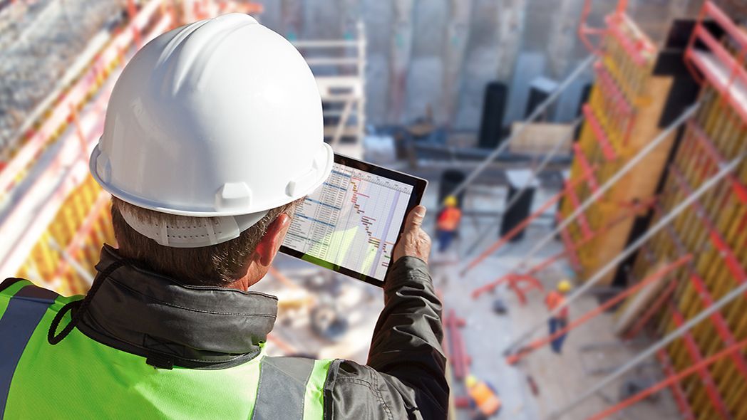 Ingenieur überwacht Baugrube per Tablet
