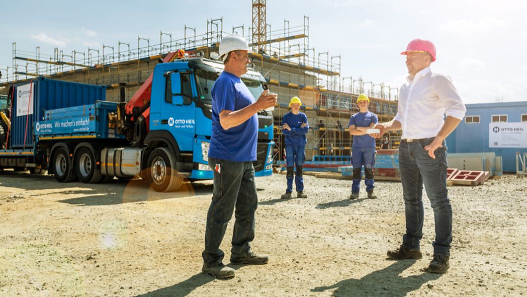 Bauarbeiter stehen auf einer Baustelle.