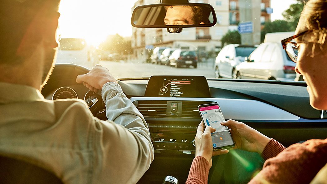 Beifahrerin nutzt Park-App im Auto