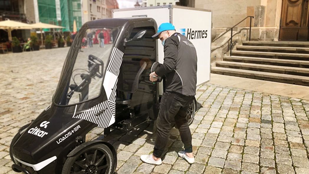Hermes-Mitarbeiter stellt Pakete mit einem Loadster von citkar zu