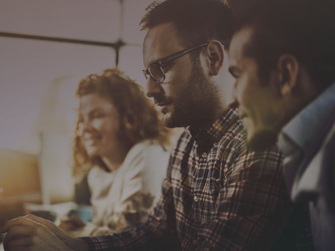 Personen blicken auf einen Bildschirm