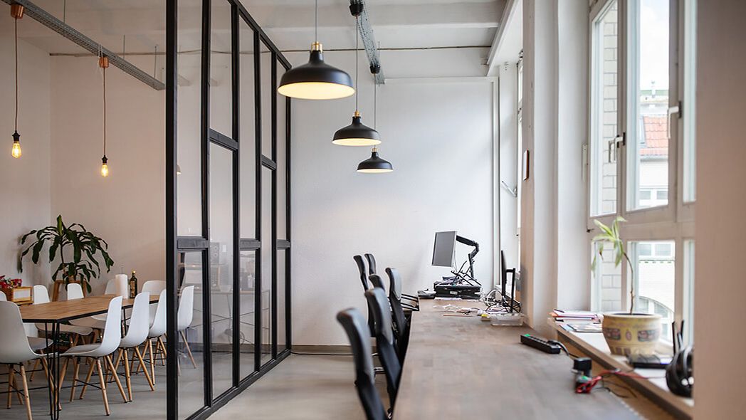 Empty open plan office with ceiling lamps and lighting on