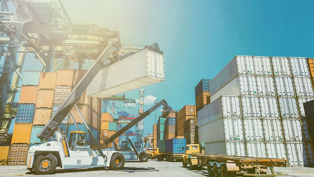 A crane stacks containers at a container yard