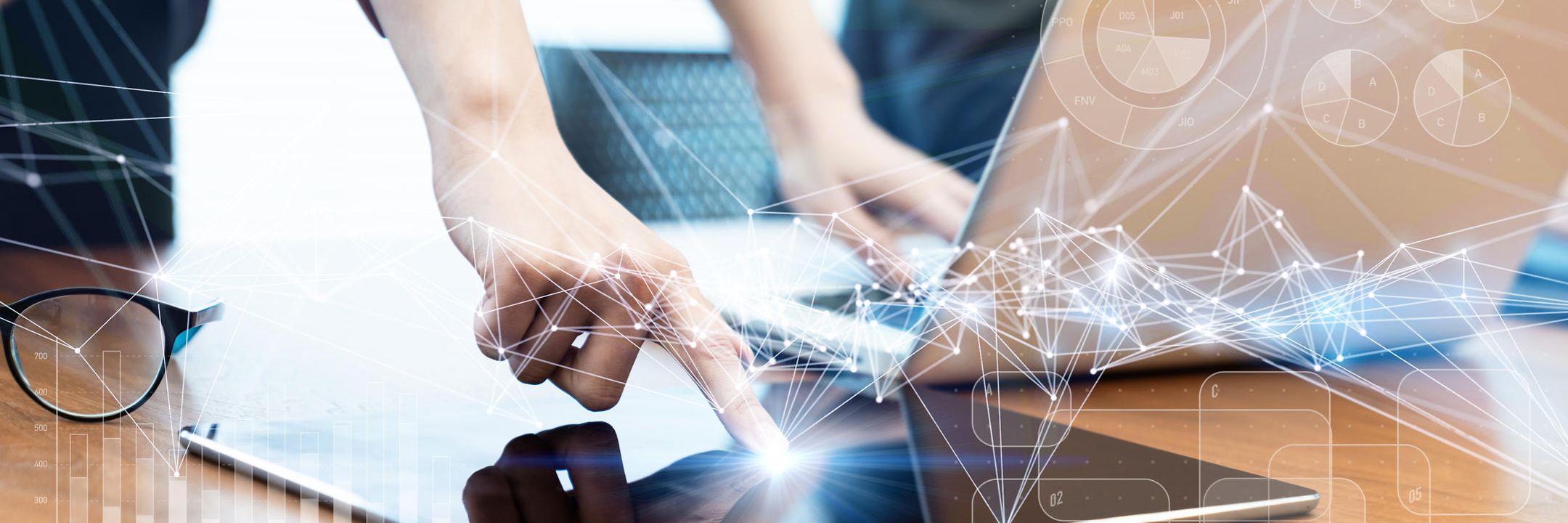 Person touching a laptop and tablet on a table with an abstract network overlay.