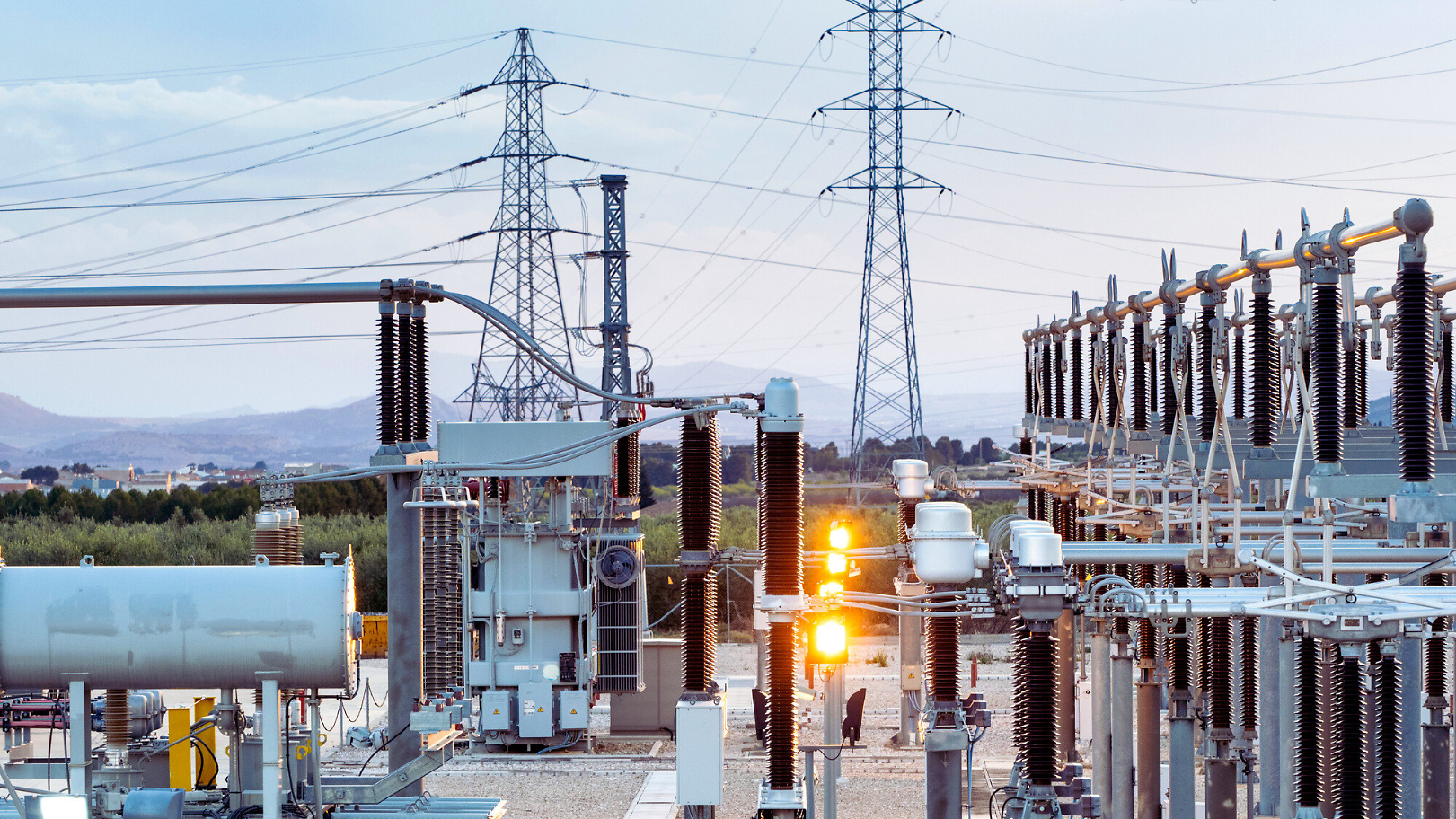 Power plant with electricity pylons in the background