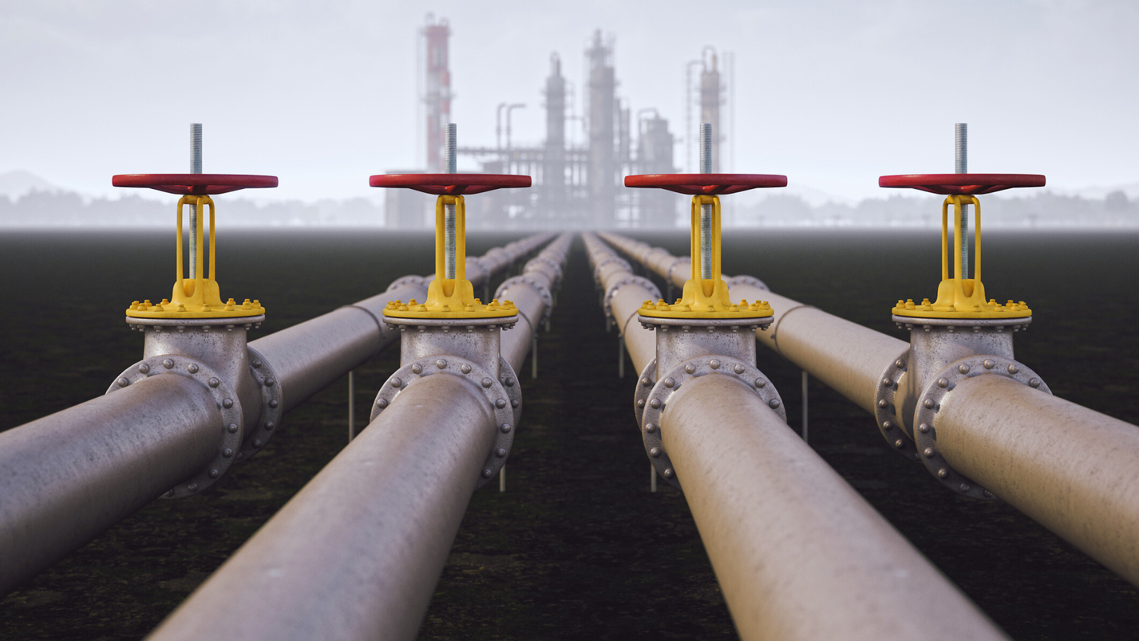 Industrielle Pipelines mit Ventilen, die eine Energieanlage im Hintergrund verbinden.