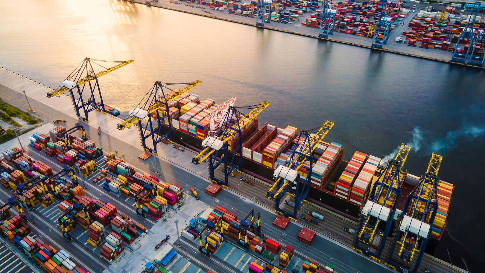 Frachthafen mit Containerschiffen und Kränen, zentral für den globalen Handel.