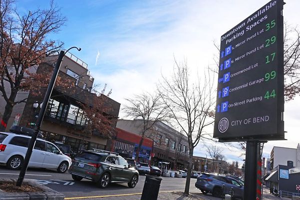 Street with cars and electronic parking sign.