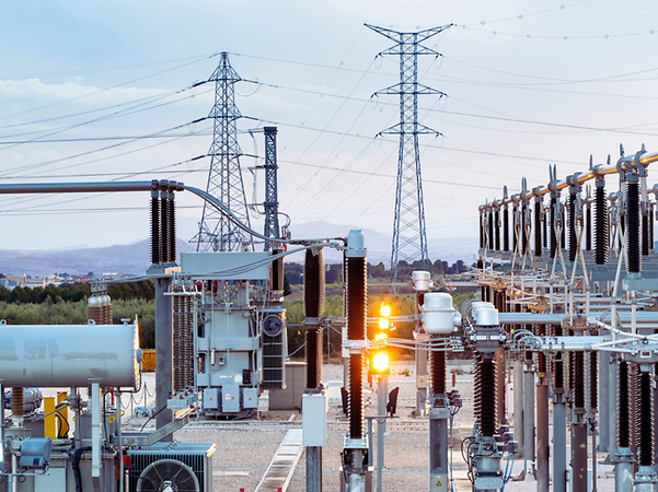 Power plant with electricity pylons in the background