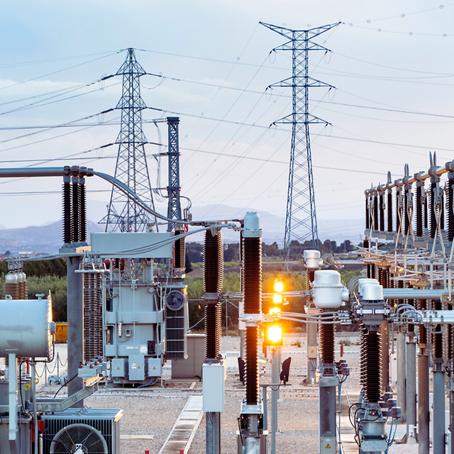 Power plant with electricity pylons in the background
