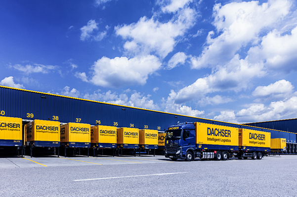 A fleet of trucks in front of a logistics center