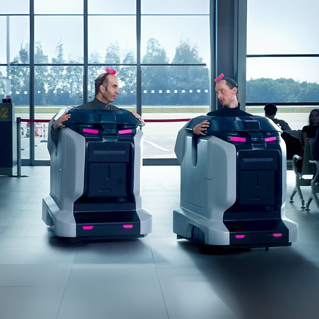 People in vacuum robot costumes in an airport hall.