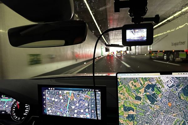 Driving through the Gotthard road tunnel, displays of sat nav and laptop with route