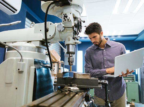 Man operating a machine with a laptop