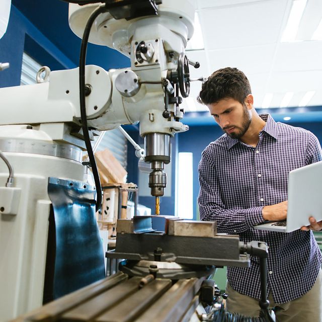Man operating a machine with a laptop