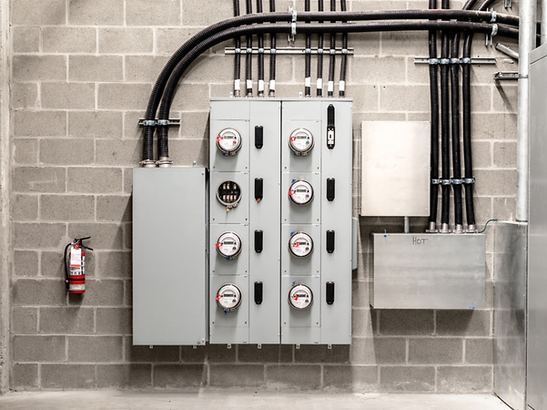 A distribution box with several electricity meters on a concrete wall.