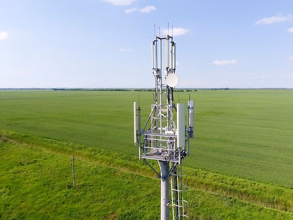 Radio mast with mobile phone antennas on a field