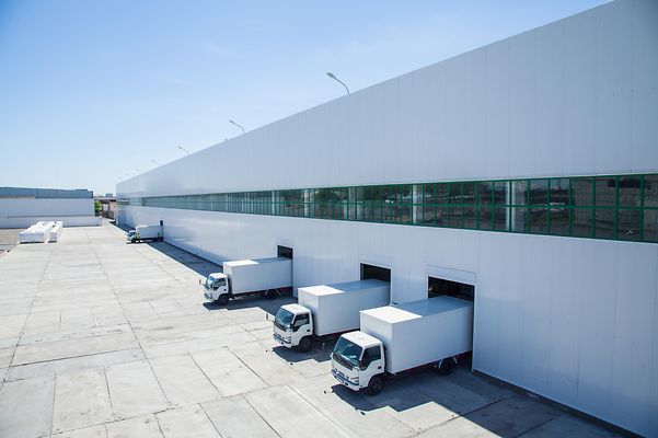 A fleet of trucks in front of a logistic center.