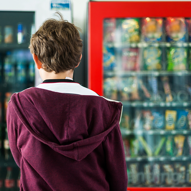 Customer in front of drinks and snack vending machines