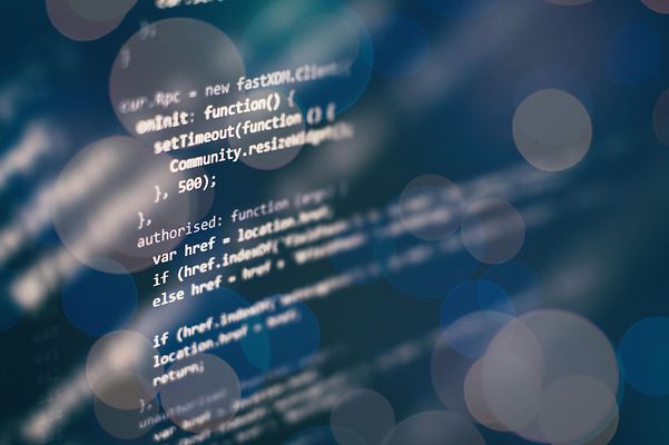 Abstract visualization of programming code with blurred light effects.