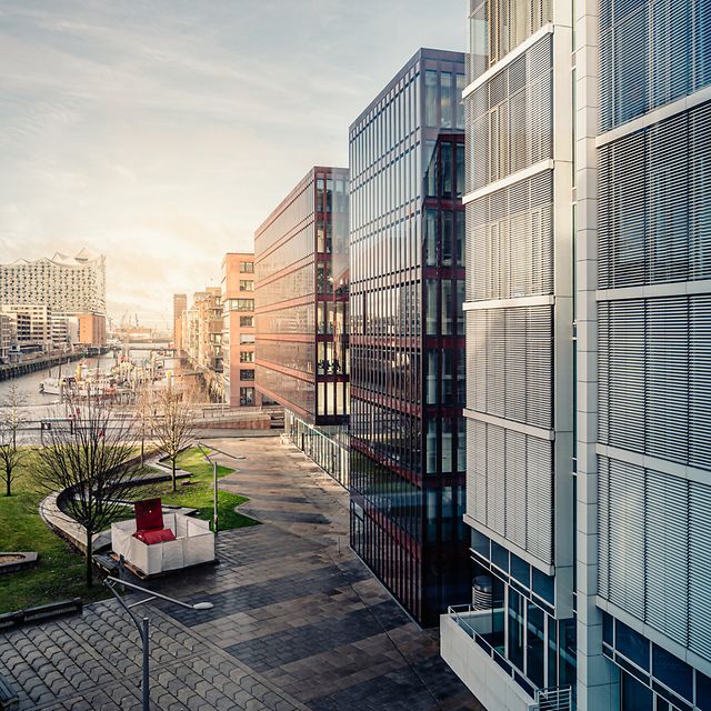 Modern buildings with glass facades and green spaces symbolize the future of smart building management