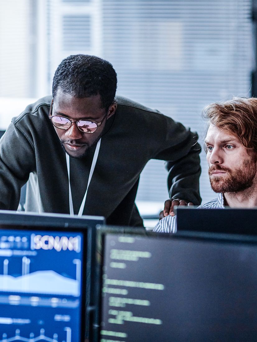Two people in the office analyze IoT data on the computer