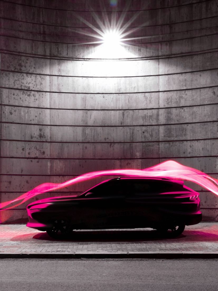 Modern car illuminated by magenta light trails symbolizing digital connectivity.