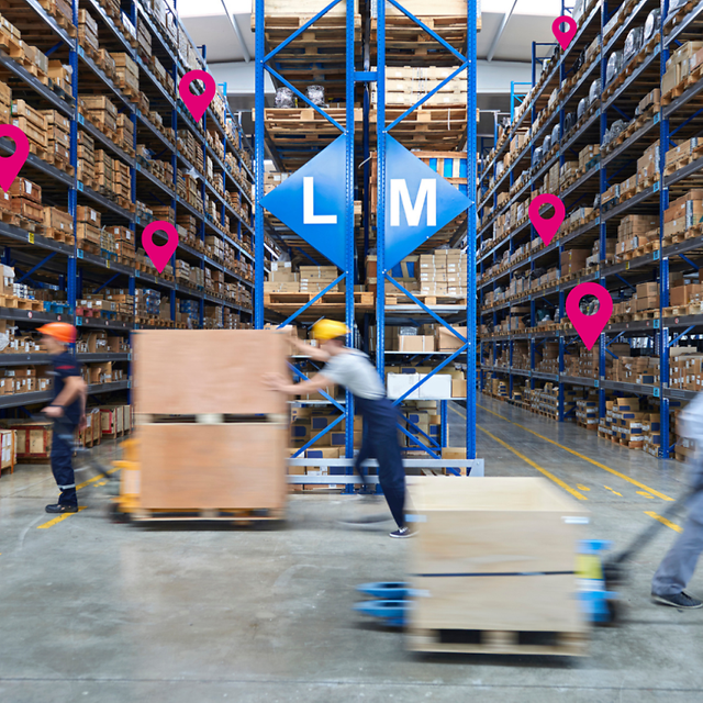 People pushing and pulling pallets, in the background large shelves with pallets and pink location icons