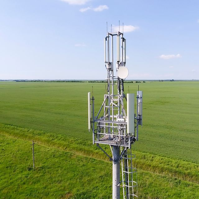 Radio mast with mobile phone antennas on a field