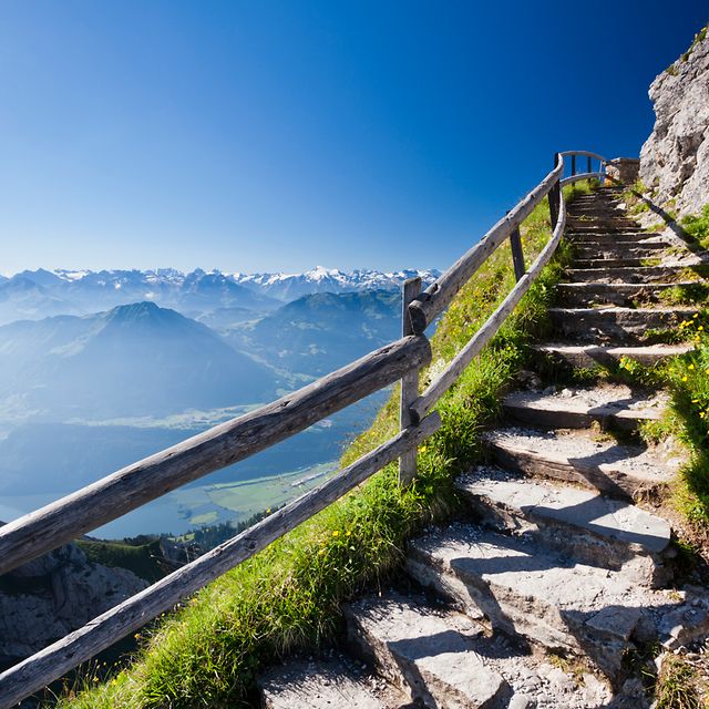 A stone staircase on a mountain leads towards the summit.