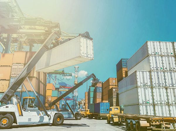 A crane stacks an IoT-connected container at a container depot.