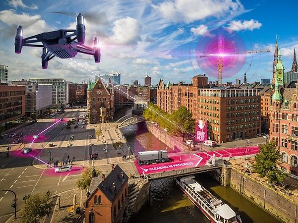En drönare flyger över staden och använder precisionspositionering för att lokalisera autonoma maskiner med centimeterprecision