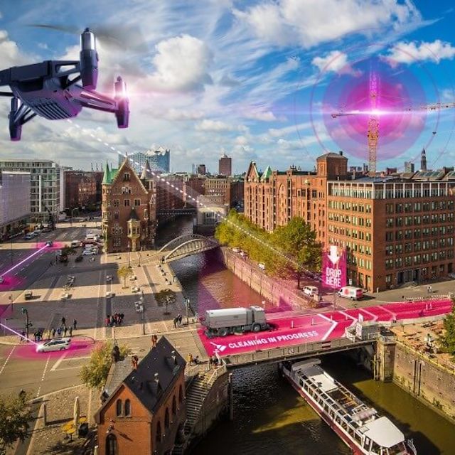 En drönare flyger över staden och använder precisionspositionering för att lokalisera autonoma maskiner med centimeterprecision