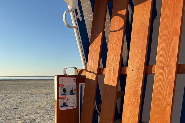 Strandstol på sand med havet i bakgrunden