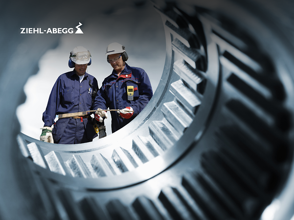 Dos ingenieros fotografiados a través de un eje de transmisión.