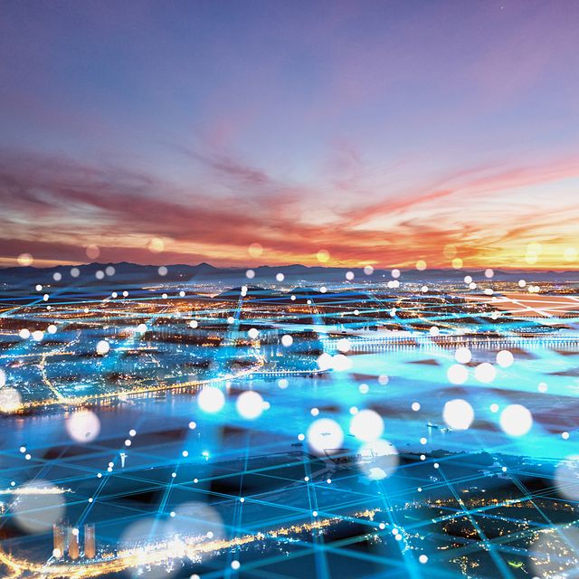 Escenario para casos de uso del IoT con una ciudad y una puesta de sol de fondo, y una superposición abstracta de una red.